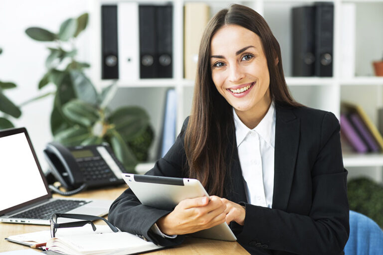 portrait-young-businesswoman-sitting-desk-holding-digital-tablet-her-hand_low-res